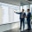 Zwei Berater besprechen die Archivierung von Spool-Listen in SAP HCM vor einem SAP-GUI-Screen im Glasbüro (KI-generiertes Bild)